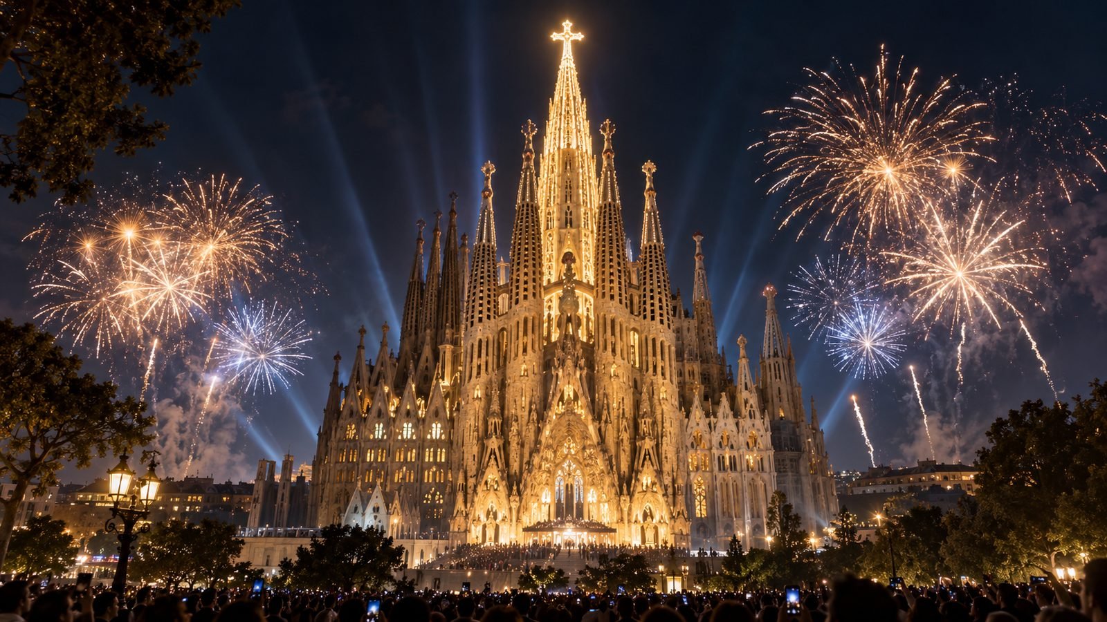 La Sagrada Família iluminada de noche, con fuegos artificiales.
